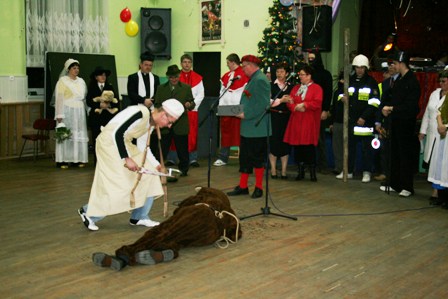 Masarz przystępuje do zebrania „krwi” misia i rozdzielenia jej pośród uczestników zabawy.