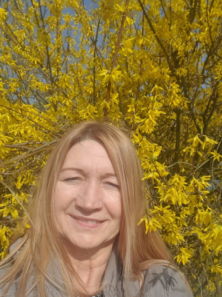 kobieta na tle krzewu z żółtymi kwiatkami