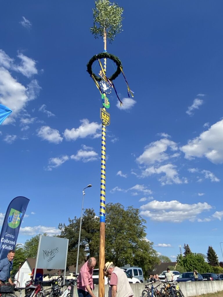 tyczka z zielonym wieńcem z niebieskożóltymi wstążkami