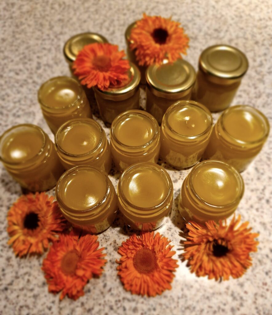 słoiczki z żółtą zawartością, a wśród nich pomarańczowe kwiatki